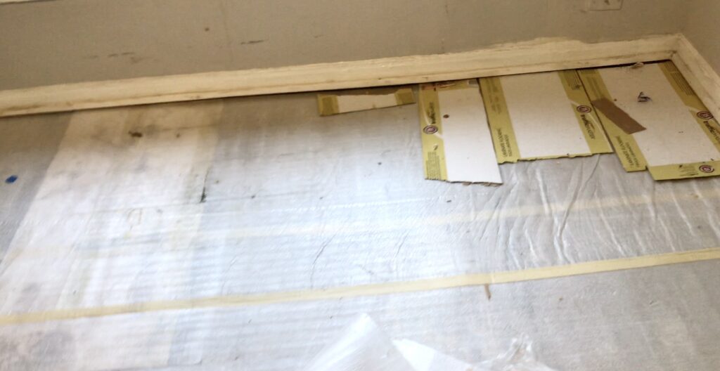 floating floor removed and exposing the lining underneath and cardboard