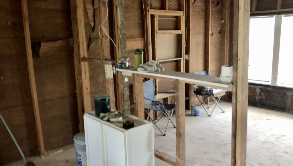 framing exposed in kitchen and living room area of tiny fixer upper