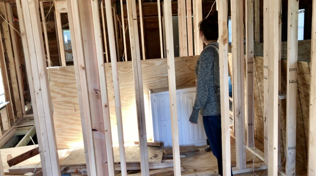 woman in closet frame of small fixer upper house