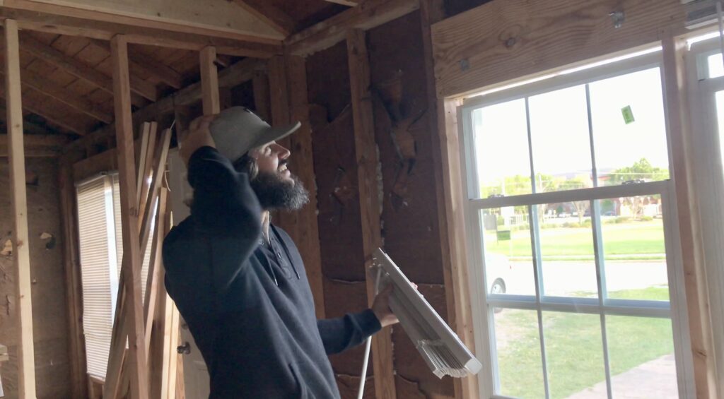 man opening colonial style windows in fixer upper