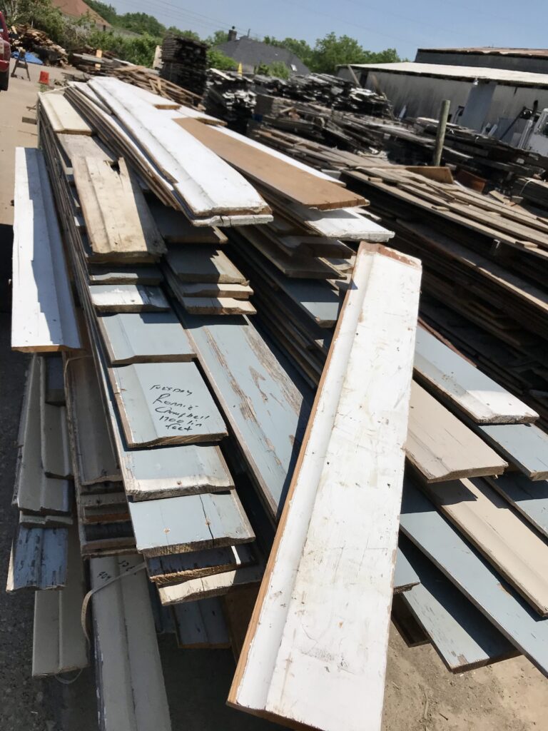 salvage yard with planks of wood stacked up