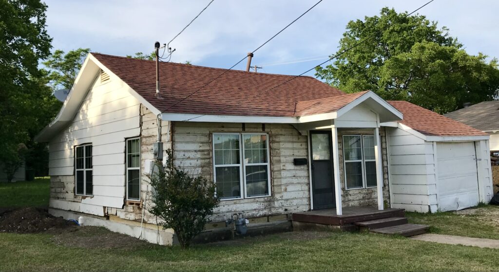 small fixer upper cottage with original siding exposed