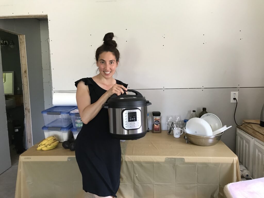 woman holding up Instant Pot in small cottage fixer upper kitchenette 