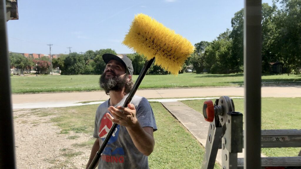man holding up scrub brush
