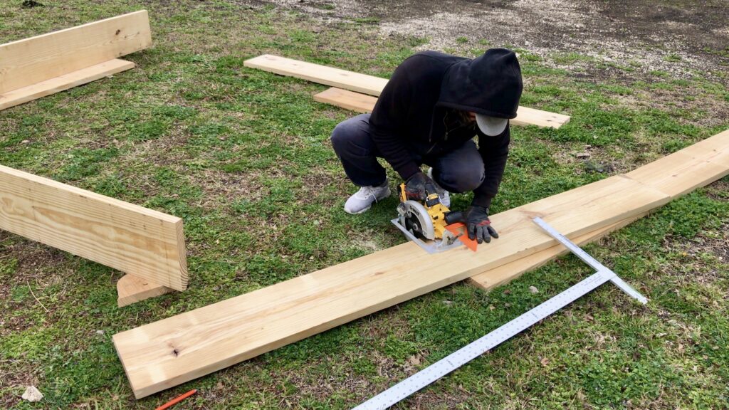 man building wood raised beds for garden