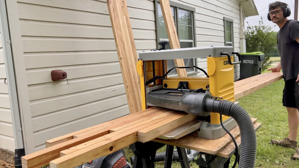 man planing butcher block countertop in planer