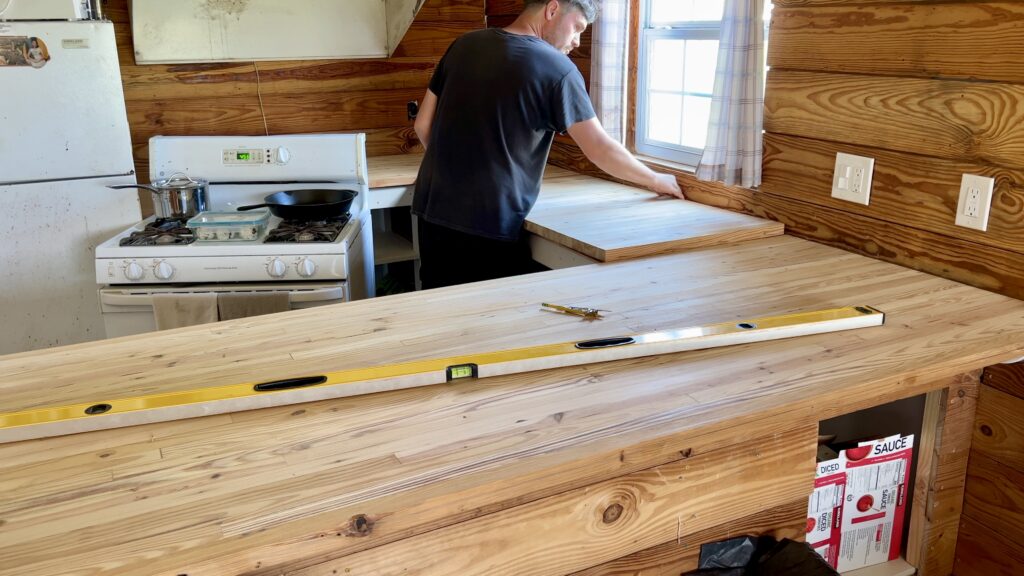 man installing custom built butcher block countertop 