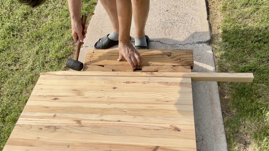 man hammering custom built clamp for butcher block countertop 