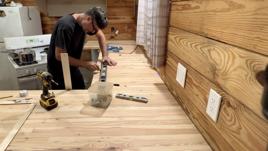 man measuring custom built butcher block countertop for kitchen sink cut out 