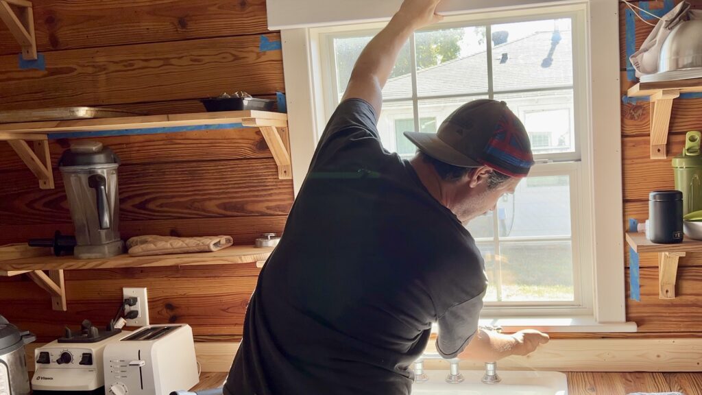 man building custom trim for windows
