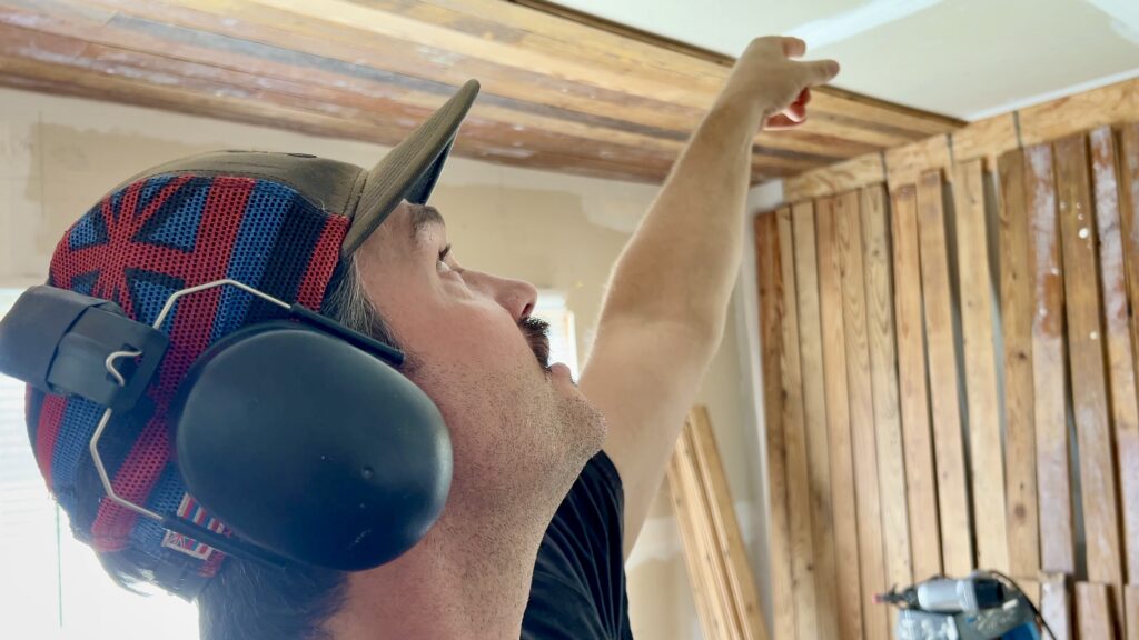 man pointing to reclaimed wood on ceiling
