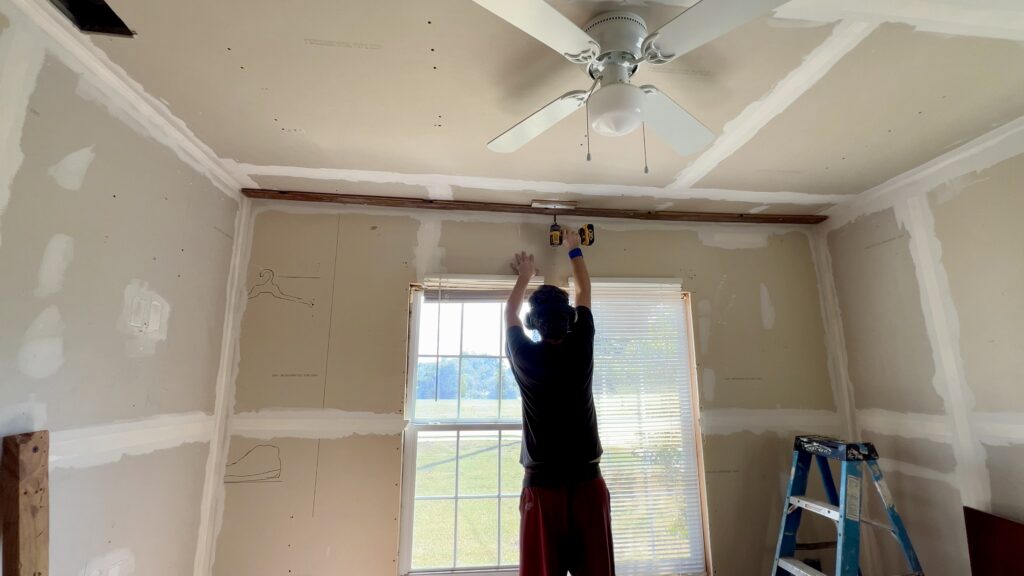 man installing reclaimed wood on ceiling
