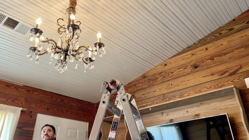 man with antique chandelier hanging in background