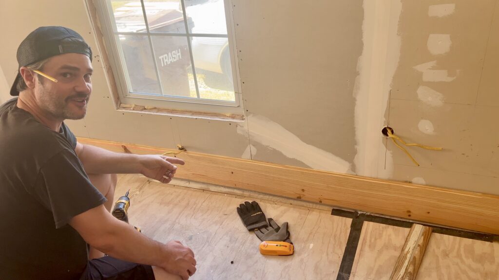 man installing new shiplap on wall